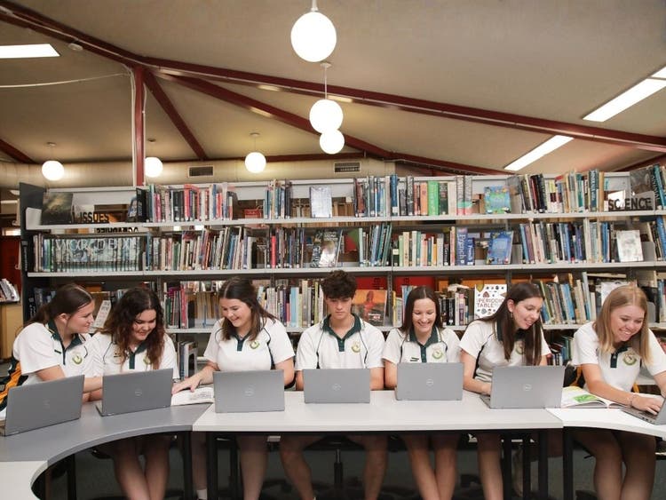 Senior students with laptops in the library