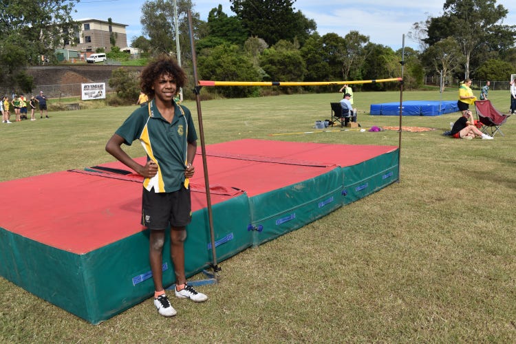 Student infront of the high jump mat on the oval