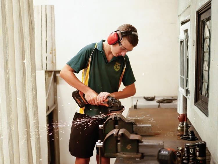 Student using a grinder in metal work