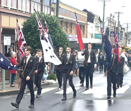 Students marching with flags in the mainstreet of Kyogle