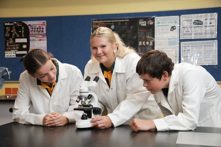 Students in white lab coats in the science lab