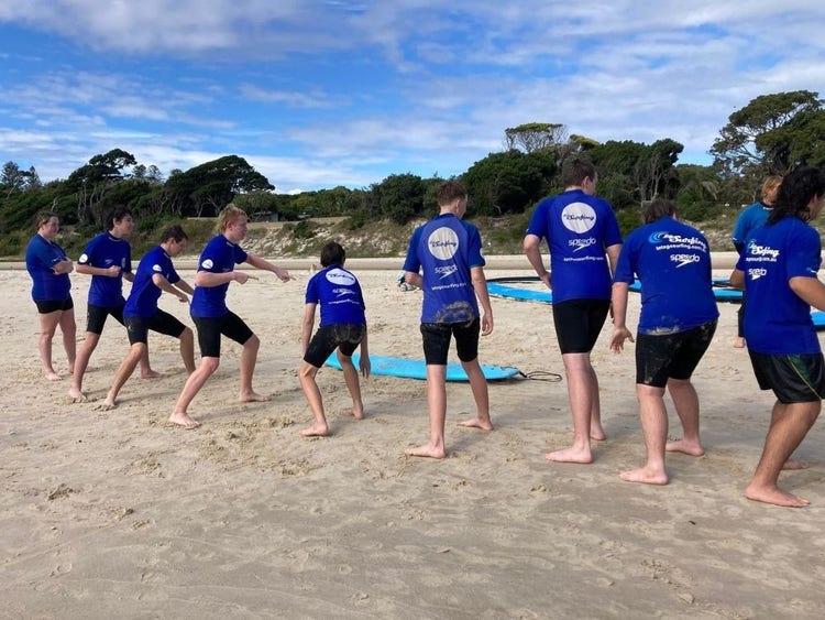 Students on the beach learning skills for surfing